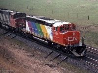 CN 5334, an SD40-2W built by GMD in 1980, was the only CN locomotive to receive an Expo 86 colour scheme.<br>
This image taken from Newtonville Road bridge shows CN 5334 leading an eastbound train in the Spring of 1985.<br> 
I believe the upper surfaces are gloss black, reflecting light from the sky.<br><br>
CN also applied Expo 86 schemes to a few of their boxcars, the diagonal stripe colours varied.

